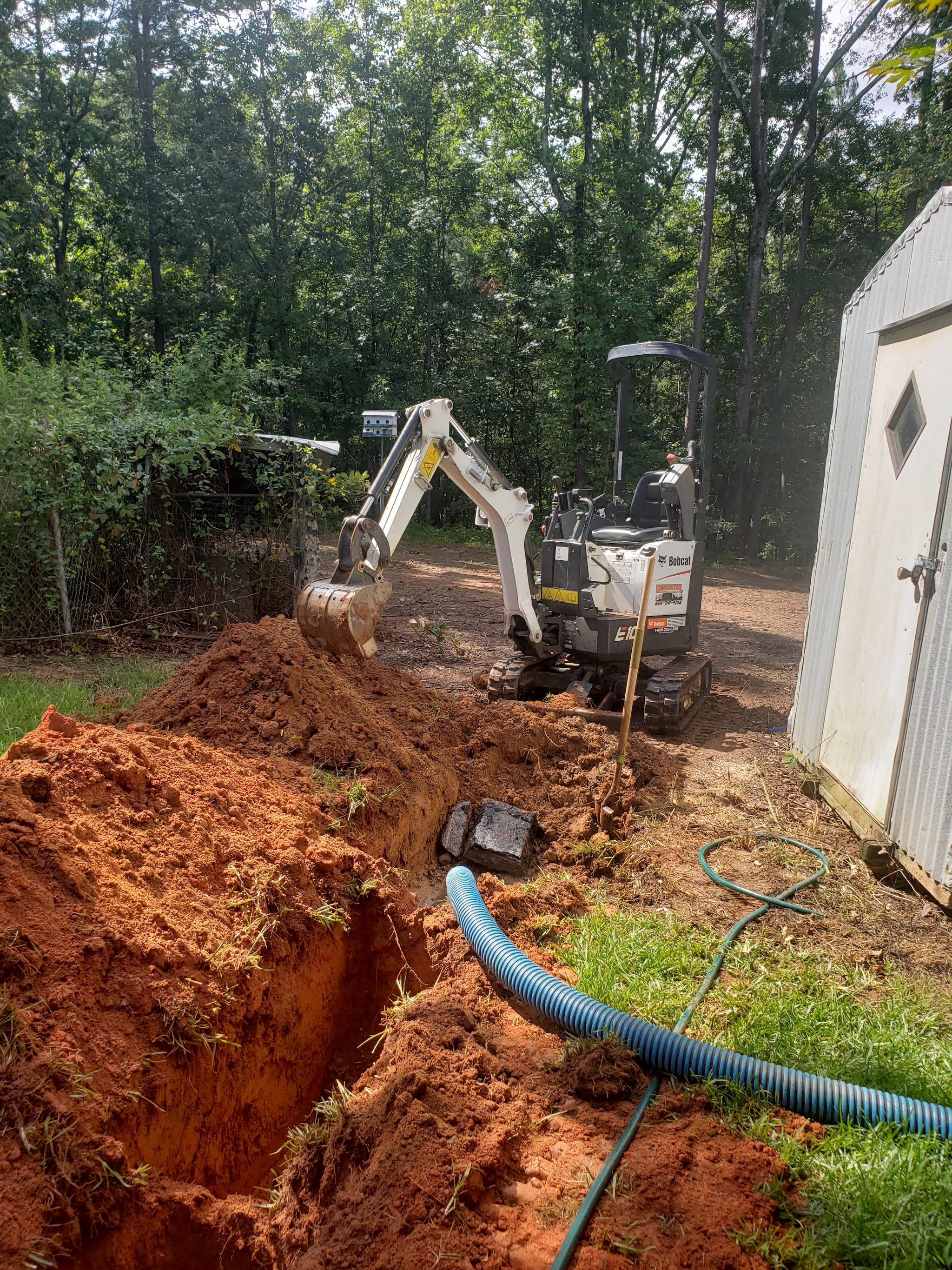 Our mini excavator digging down to a septic tank in a backyard